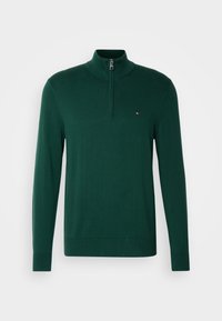 Pull vert foncé à manches longues avec une fermeture éclair au quart et un petit logo drapeau Tommy Hilfiger sur la poitrine gauche.