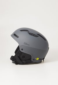 Gray ski helmet with ventilation slots, textured lower half, and adjustable straps. Features "Mips" safety technology sticker.