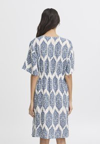 Patroon katoen jurk met een blauw-wit geometrisch ontwerp, korte mouwen en een elastische taille voor een comfortabele pasvorm.