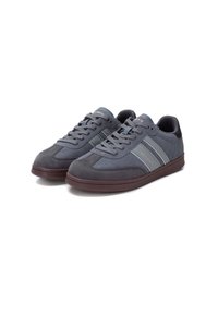 Zapatillas de ante gris con diseño de cordones, rayas en un gris más oscuro y una suela de goma con una base texturizada marrón.