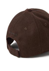 Cappellino da baseball in lana marrone con cinturino regolabile, fori di ventilazione cuciti e un bottone in tessuto sulla parte superiore, mostrato da dietro e di lato.