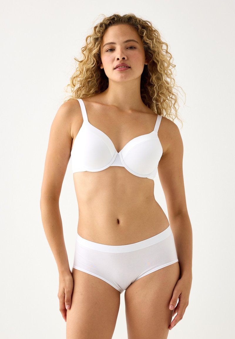 Reggiseno imbottito bianco con spalline regolabili in tessuto liscio. Abbinato a slip bianchi coordinati a vita alta, entrambi con un design senza cuciture.