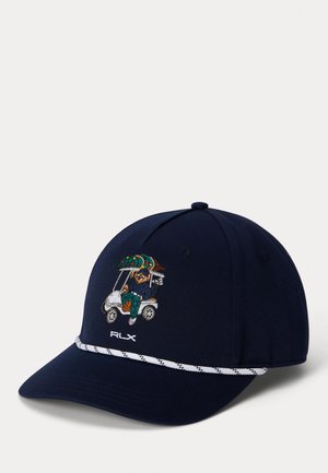 Navy baseball cap with white embroidered logo and patterned band. Features a detailed embroidered design of a figure in a golf cart.