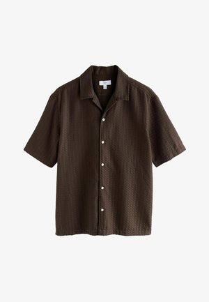 Pruun lühikeste varrukatega pluus tekstuurse kangaga, avatud krae ja kuus valget nööpi ees. Lõdva istuvusega ja mugava disainiga.