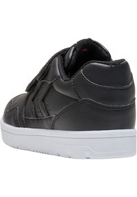 Czarne skórzane sneakersy z płaską białą gumową podeszwą, wyściełanym kołnierzem i rzepem. Charakteryzują się geometrycznymi przeszyciami.