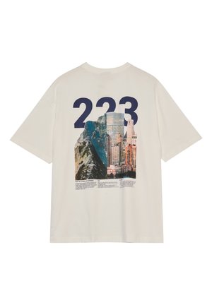 Off-white T-Shirt mit großer dunkelblauer "223" über einer Grafik, die einen Berg und eine Stadtsilhouette verbindet, sowie kleinem gedrucktem Text unter dem Bild.