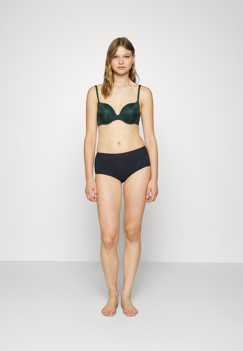 Soutien-gorge rembourré vert foncé avec des fines bretelles, associé à des culottes en coton noires taille haute. Design simple, texture lisse et bords sans couture.