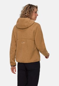 Tan fleece hoodie med huva, texturerad yta och en sydd panel. Har en liten logotypdetalj på baksidan och långa ärmar.