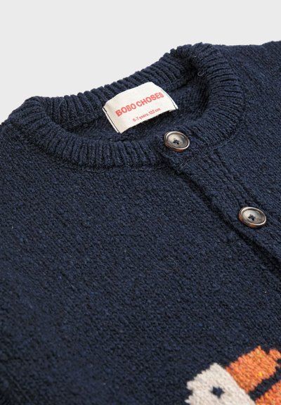 Marinefarbener, knöpfbarer Pullover mit strukturiertem Strickmuster, runder Ausschnitt und einem Fuchsdesign in Orange und Creme. Markenlabel vorhanden.