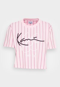 Kortärmad rosa t-shirt med vertikala vita och röda ränder. Har svart och vitt grafiskt text och rund halsringning.