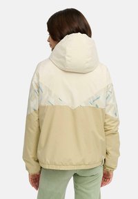 Lichtbeige jas met een patroon op het achterpaneel, featuring geometrische vormen en een zachte textuur. Hoodie ontwerp met elastische manchetten en onderkant.