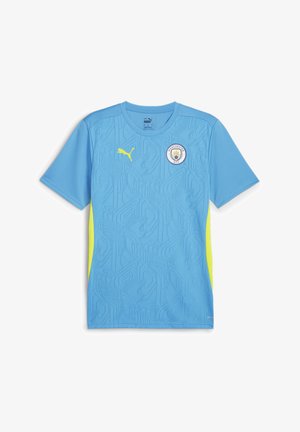 Camiseta de fútbol de manga corta de color azul claro con patrón texturizado, acentos laterales en amarillo y el logo del Manchester City en el pecho. Fabricada con material sintético.