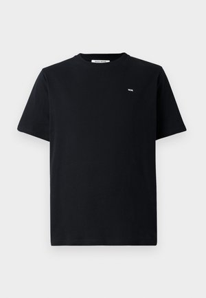 Melnas kokvilnas t-krekls ar apaļu kaklu, īsām piedurknēm un mazu baltu logo uz krūškurvja. Regulāra piegriezuma ar gludu tekstūru.