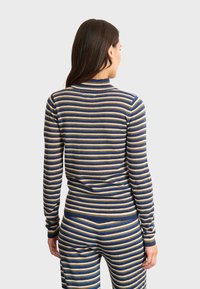 Gestreifter Strickpullover in Blau, Gold und Grau, mit hohem Kragen und gerippten Bündchen. Die Rückansicht zeigt eine figurbetonte Silhouette und einen strukturierten Stoff.