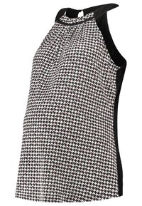 Top maternità con un motivo a scacchi bianco e nero e accenti rossi, design a collare halter e pannelli laterali neri. Tessuto morbido.