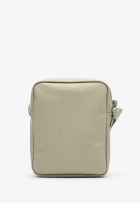 Bolso rectangular hecho de tela beige con una superficie texturizada, que cuenta con un cierre superior y una correa lateral para llevar.