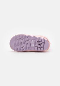 Sneaker rosa con una suola in gomma viola testurizzata che presenta un motivo a zig zag e un marchio impresso per maggior aderenza e dettagli stilistici.