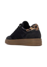 Zapatillas negras con una parte superior de cuero texturizado y gamuza. Presentan un acento de estampado de leopardo en el talón y una suela de goma.