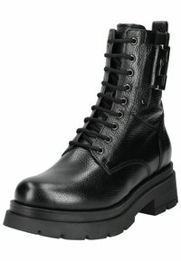 Botte chelsea en cuir noir à lacets, avec une finition texturée, une semelle épaisse, un bout rond et un détail de boucle sur le côté.