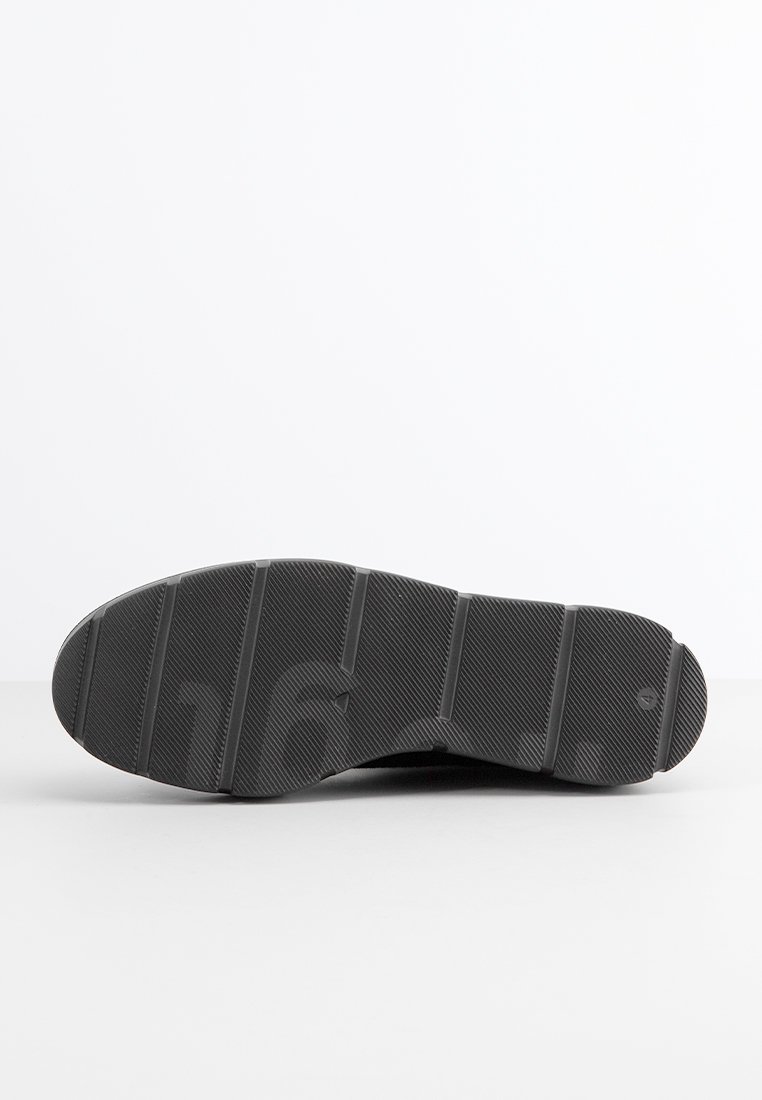 Suola di scarpa in gomma nera con superficie testurizzata, caratterizzata da scanalature orizzontali e punta arrotondata. Nessun marchio visibile o dettagli distintivi.