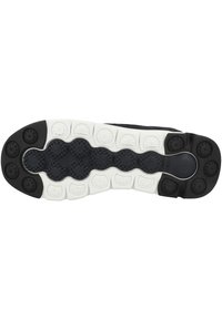 Suola di scarpa sportiva bianca e nera caratterizzata da un motivo di grip testurizzato, dettagli arrotondati e un design leggero per il massimo comfort.