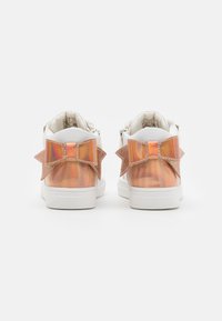 Hvide sneakers med iriserende gennemsigtige paneler og rosa glimmer sløjfer på bagsiden. Tekstureret detaljering på hælen.