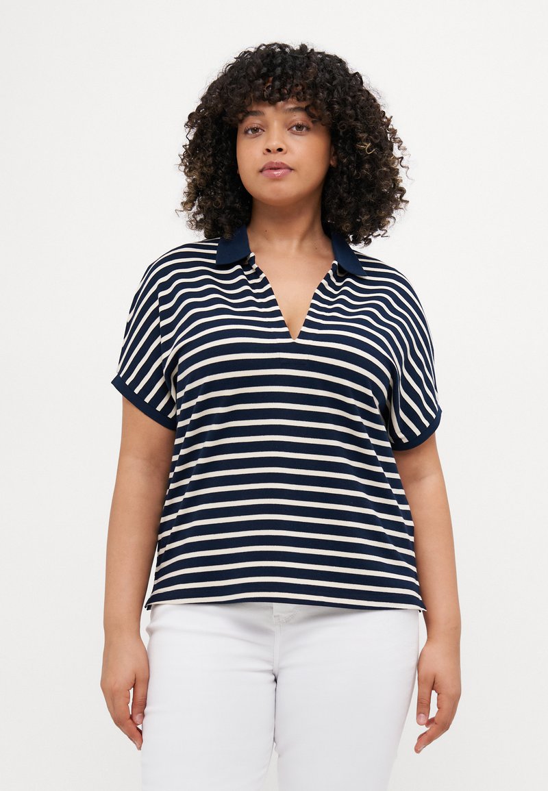Polo a righe navy e crema con scollatura a V, maniche corte e colletto a tinta unita. Tessuto morbido con una vestibilità rilassata.