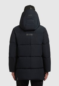 Jachetă puffer izolată de culoare neagră, cu glugă, având un design capitonat și un finisaj mat. Include un accent reflective și manșete ajustabile.