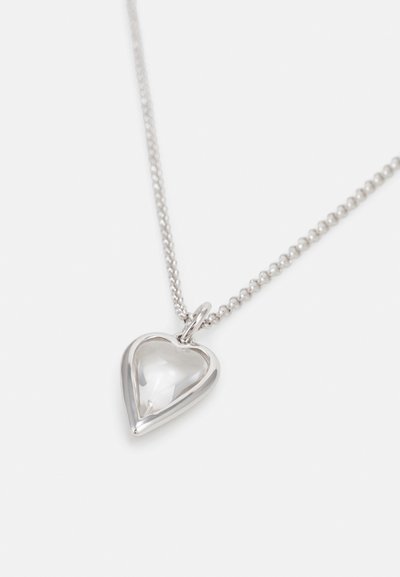 Silver heart pendant necklace with a polished, reflective surface and a light-catching design, suspended on a chain with small round links.