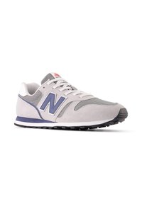 Sneaker grigie chiare con tomaia in rete e camoscio, caratterizzate da un logo "N" blu scuro, una suola intermedia bianca e una suola in gomma nera.