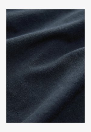 Tamno mornarska tkanina koja pokazuje glatku teksturu s suptilnim valovitim uzorcima i blagim sjajem, pogodna za različite tekstilne primjene.