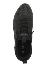 Svart träningssko med texturerad stickad överdel, snörningsdesign, rundad tå och varumärke på tungan. Platt, flexibel sula, storlek 38.