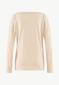 Beige långärmad tröja med en mjuk textur, vid halsringning och ribbade ärmslut. Enkel, odekorerad design med en avslappnad passform.