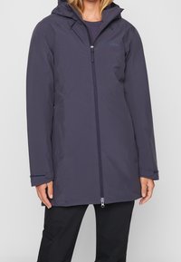 Granatowy, wodoodporny płaszcz z kapturem, zamkiem na całej długości i regulowanymi mankietami. Charakteryzuje się gładką fakturą oraz detalami z logo na piersi.