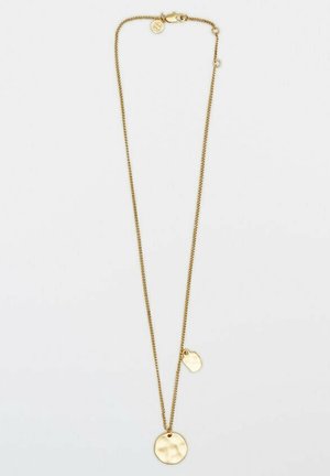 Collier chaîne en or avec un pendentif rond martelé et un petit charme de forme irrégulière sur fond blanc.