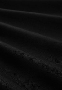 Tejido negro con una textura acanalada, que presenta ondas y pliegues suaves. La superficie parece mate sin ningún patrón o acento visible.