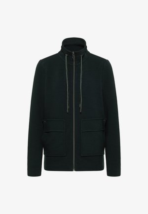 Chaqueta de cremallera en verde oscuro con un alto cuello, dos bolsillos frontales y tejido texturizado. Incluye cordón ajustable con puntas metálicas.