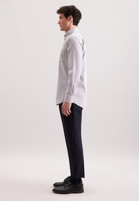 Licht paarse en witte geblokte overhemd met lange mouwen, gecombineerd met donkere slim fit broeken en zwarte leren schoenen. Eenvoudig ontwerp met een op maat gemaakte pasvorm.