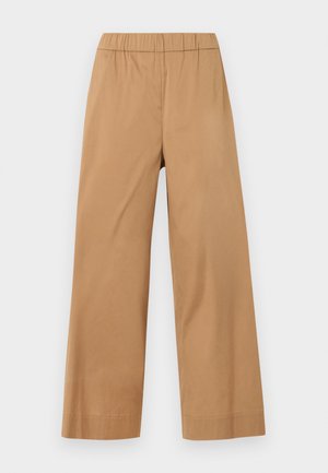 Pantalon beige à jambes larges avec taille élastique, sans poches ni fermetures visibles, présenté sur un fond clair uni.