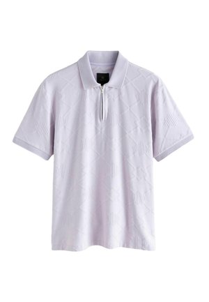 Šort-sleeve polo krekliņš gaismas lavandas krāsā ar teksturētu dimanta rakstu, pus-zip un vienkāršu apkakli. Audums šķiet mīksts un elpojošs.