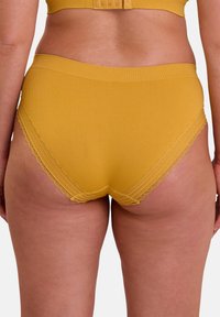Sous-vêtements en tissu à riban jaune avec des bordures en dentelle, design taille haute, texture douce et silhouette ajustée.