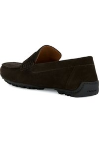 Braune Wildlederslipper mit einer strukturierten Oberfläche, runder Zehenpartie, gepolstertem Kragen und einer schwarzen Gummisohle mit dem Geox-Logo.
