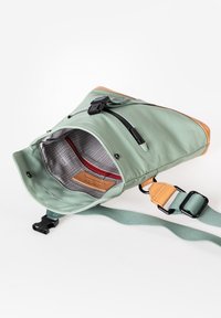 Borsa a tracolla verde in nylon con accentuazione in pelle beige, chiusure con zip, tasca interna rossa e tracolla regolabile.