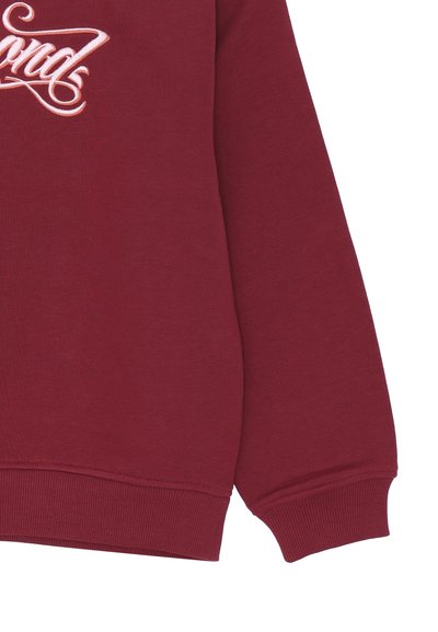 Felpa a maniche lunghe bordeaux con polsini e orlo a coste, con testo ricamato in bianco sul davanti. Materiale in cotone morbido.