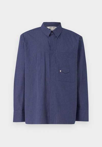 Camicia a maniche lunghe a scacchi blu navy con colletto a bottoni, taschino singolo sul petto e un sottile motivo a griglia bianca. Materiale misto cotone.