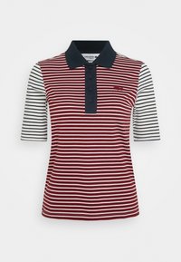 Polo rayé rouge et blanc avec col bleu marine, manches courtes et trois boutons. Comprend un logo brodé sur la poitrine.