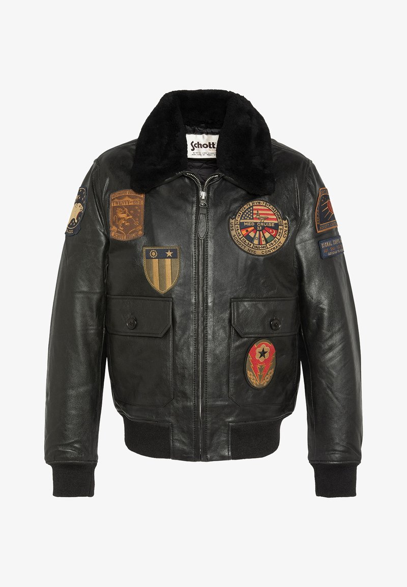 Schwarze Lederbomberjacke mit einem Kunstfellkragen, ausgestattet mit mehreren gestickten Aufnähern, zwei Fronttaschen sowie gerippten Bündchen und Saum.