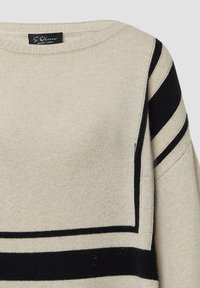 Beżowy sweter dziany z czarnymi poziomymi paskami. Ma okrągły dekolt i teksturowaną tkaninę. Metka widoczna przy kołnierzu.