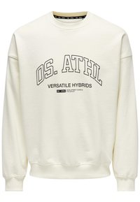 Cremefarvet sweatshirt i blødt stof med rund hals, ribbede manchetter og trykt tekst: "OS. ATHL VERSATILE HYBRIDS" præsenteret tydeligt.