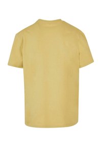 Camiseta de manga corta en algodón color amarillo pálido. Presenta un escote redondo y un corte recto sin patrones ni adornos.